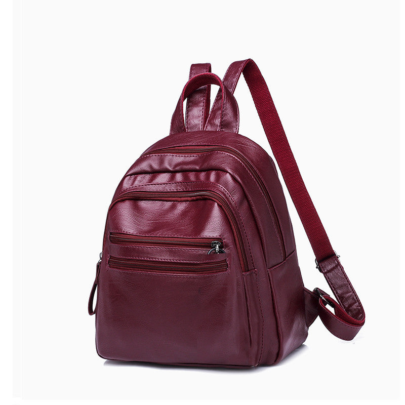 A stylish solid color lady's leather backpack with car suture detailing, perfect for business and casual use.