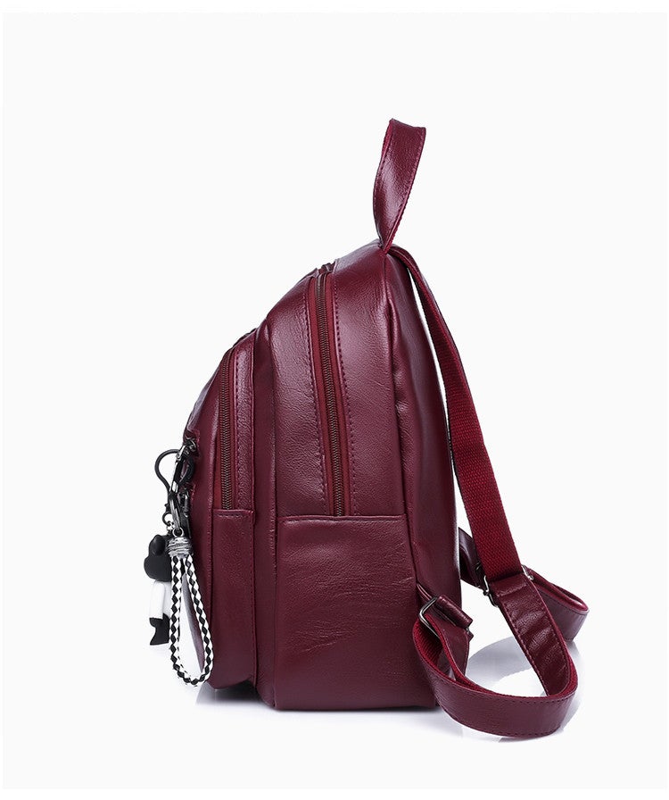 A stylish solid color lady's leather backpack with car suture detailing, perfect for business and casual use.