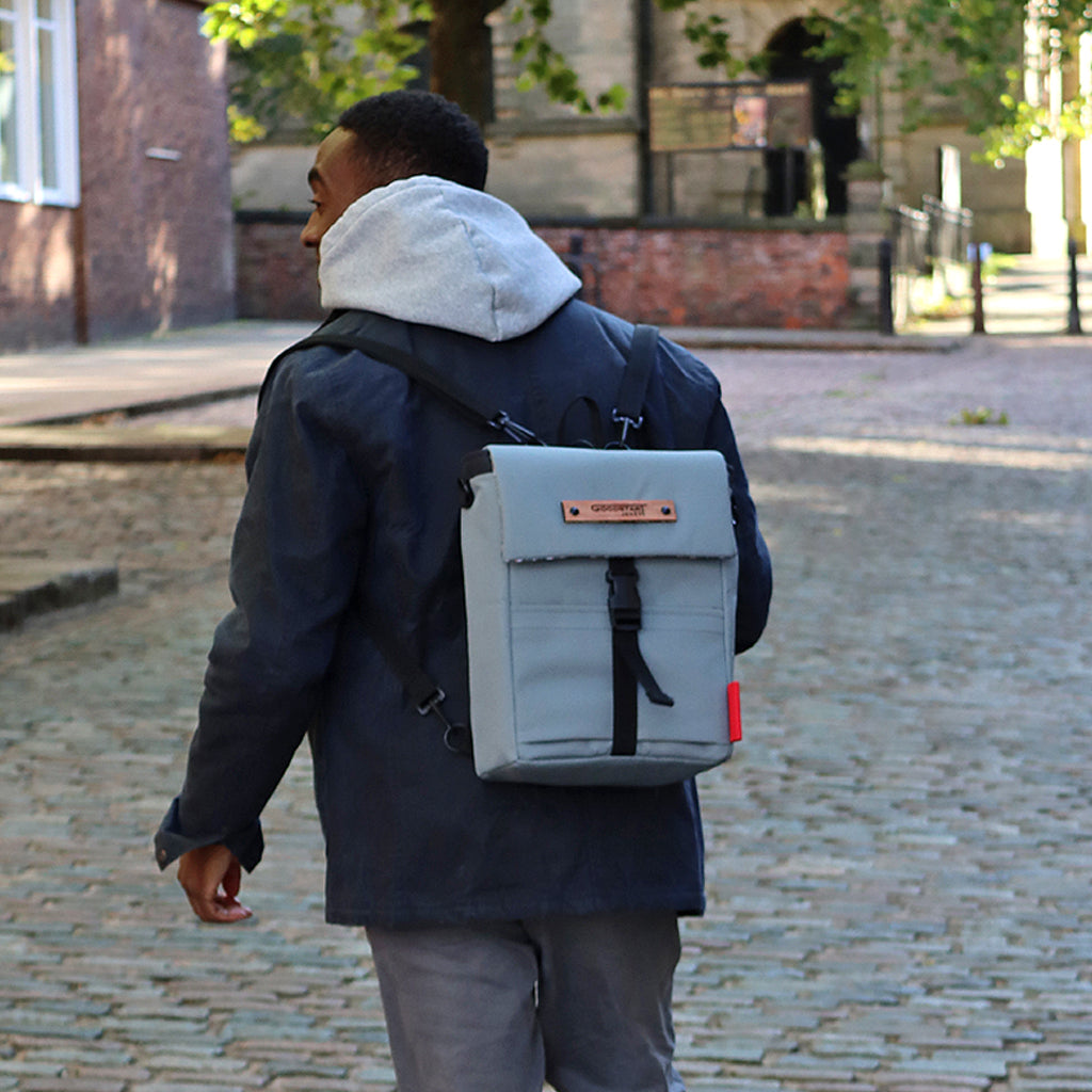 Mini Merchant Backpack in Grey, showcasing its sleek design and multifunctional features as a backpack and crossbody bag.