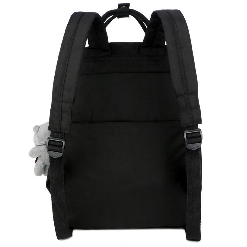 Nylon large capacity multi-function backpack featuring a cute toy bear, showcasing its spacious design and soft straps.