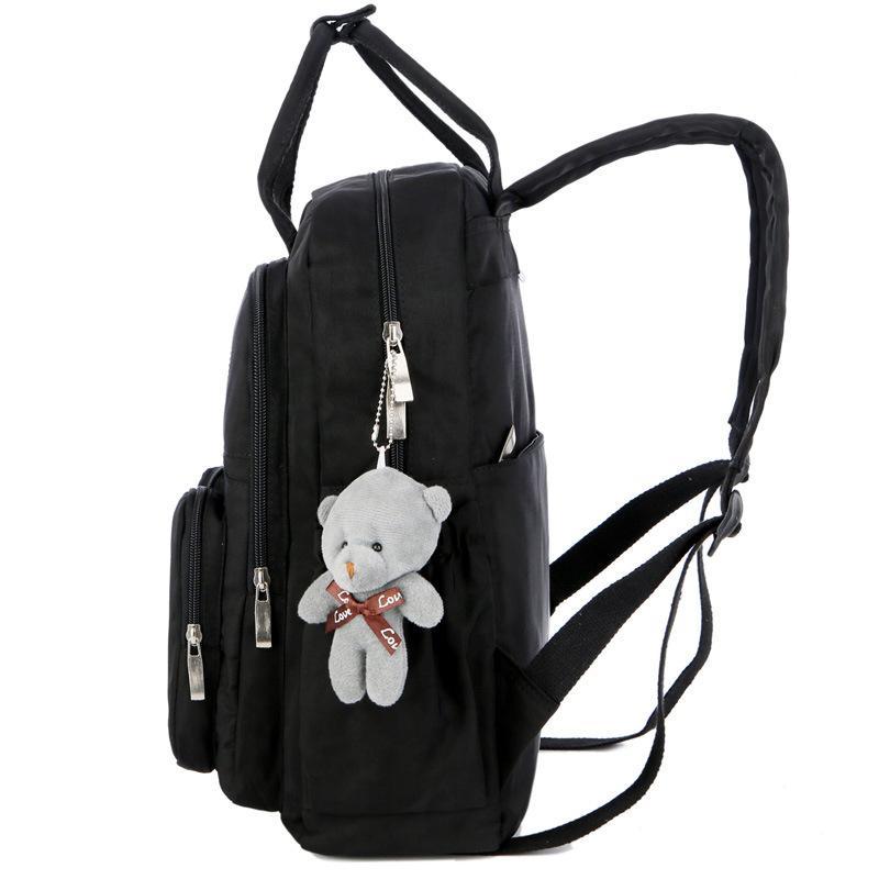 Nylon large capacity multi-function backpack featuring a cute toy bear, showcasing its spacious design and soft straps.