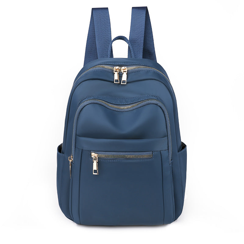 A stylish Oxford cloth backpack in plain design, featuring multiple compartments and a zipper opening, ideal for travel and daily use.