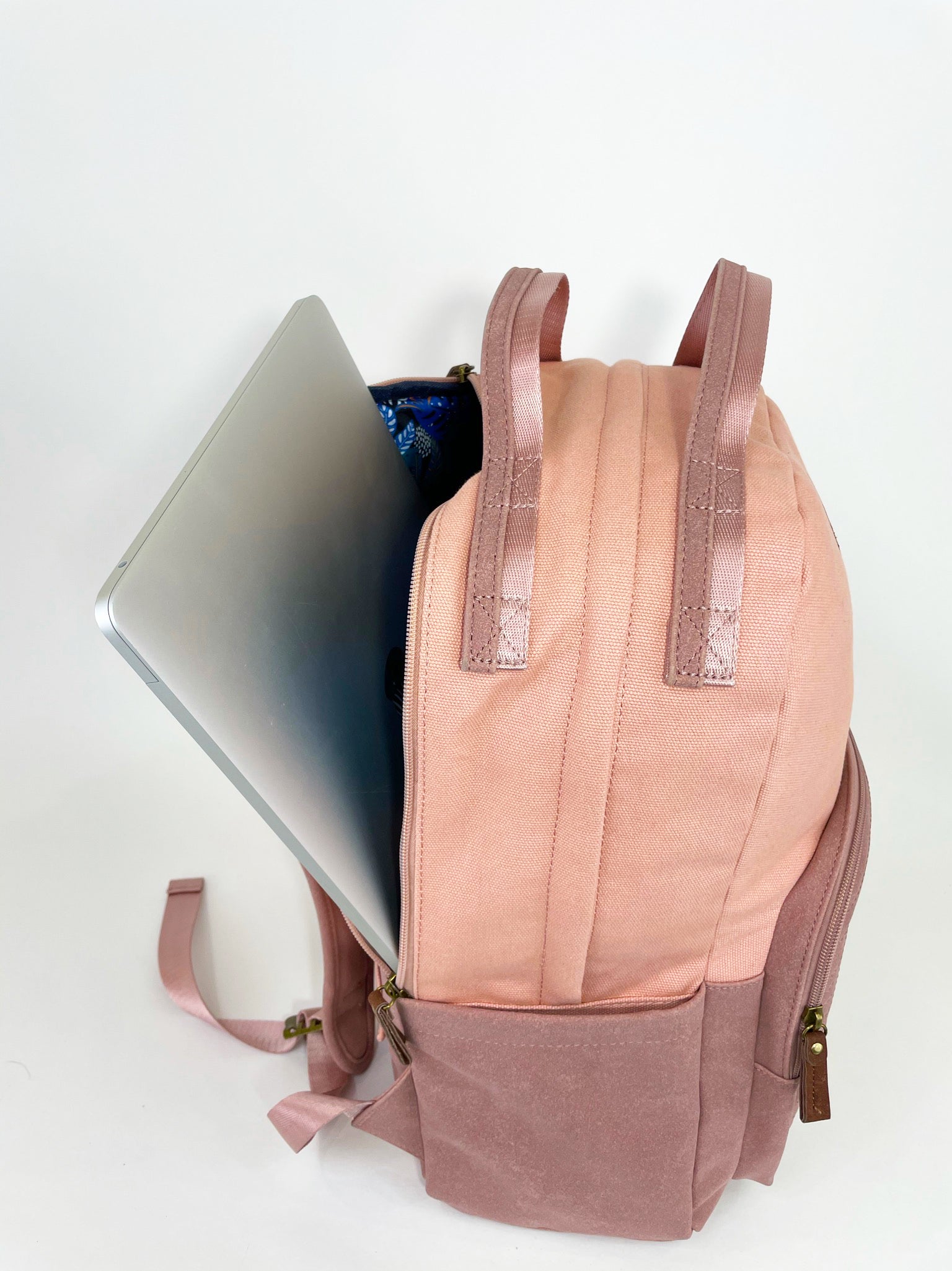 Stylish pink backpack with multiple pockets and a sleek design, featuring a secret back pocket and dedicated laptop compartment.