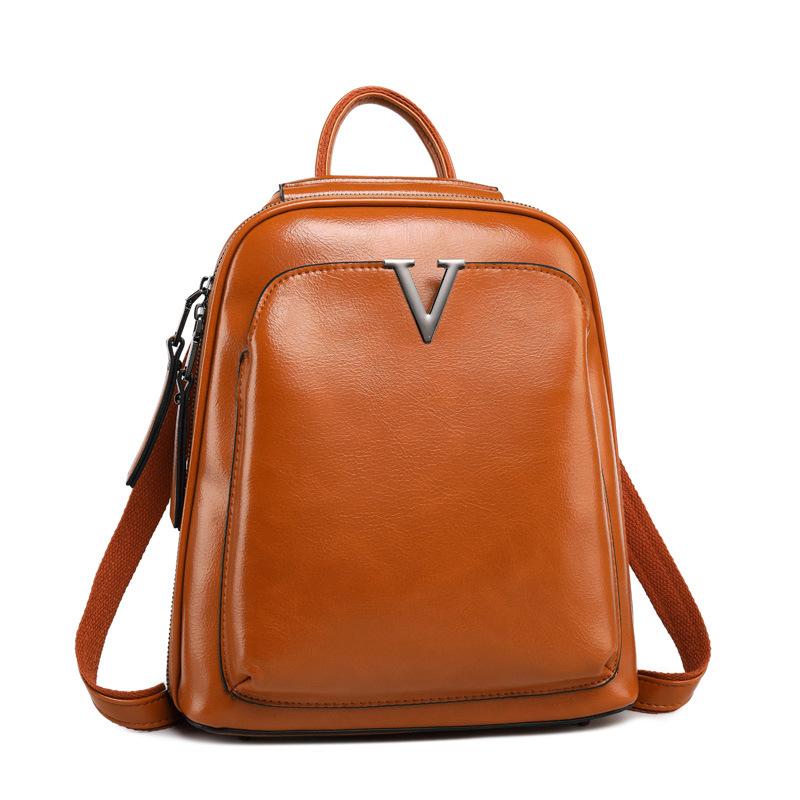 V Leather Backpack in Black made from top grain leather with adjustable shoulder strap and brass hardware, featuring multiple compartments.