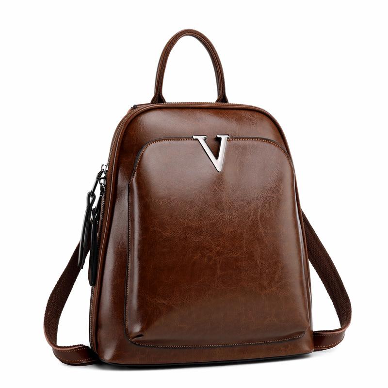 V Leather Backpack in Black made from top grain leather with adjustable shoulder strap and brass hardware, featuring multiple compartments.