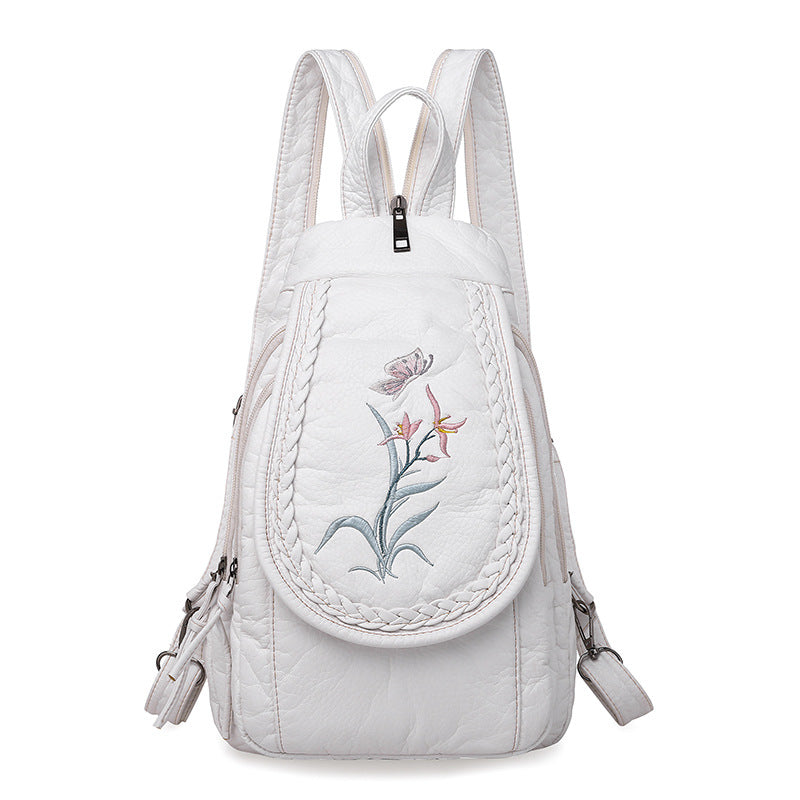 Women's Casual Backpack featuring elegant orchid embroidery in pink and white, designed for stylish everyday use.