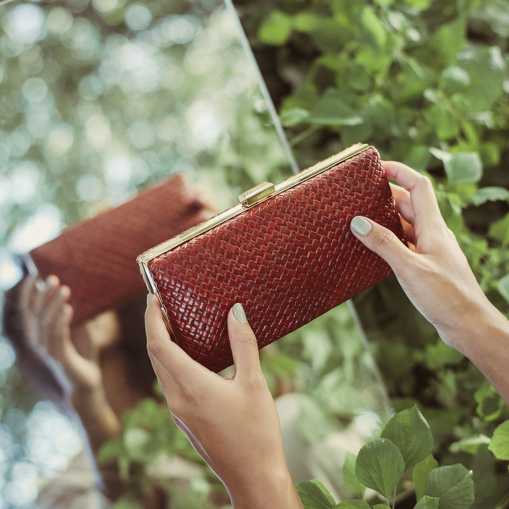 Gitta Cocoa Handwoven Straw Clutch featuring a shiny gold frame and black velvet lining, crafted from natural pandan straw.