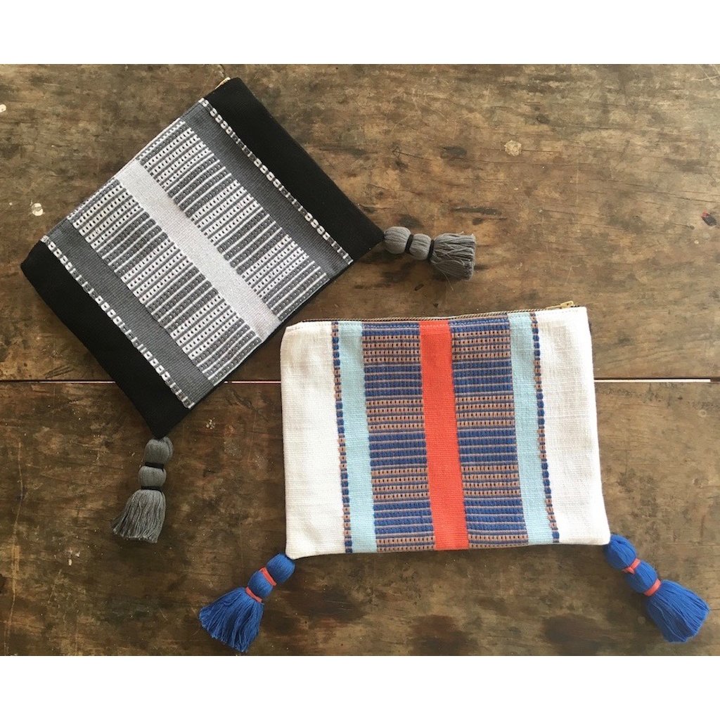 White Striped Backstrap Clutch handmade from cotton, featuring vibrant stripes and tassels, showcasing traditional Guatemalan weaving techniques.