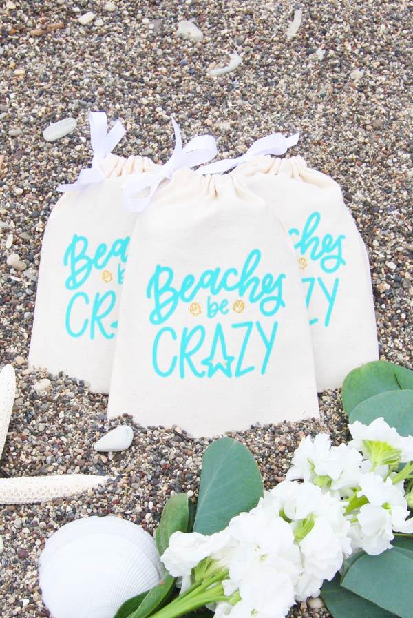 Beaches Be Crazy Hangover Kit Bags featuring glittery gold seashells and minty teal lettering, perfect for beach events and gifts.