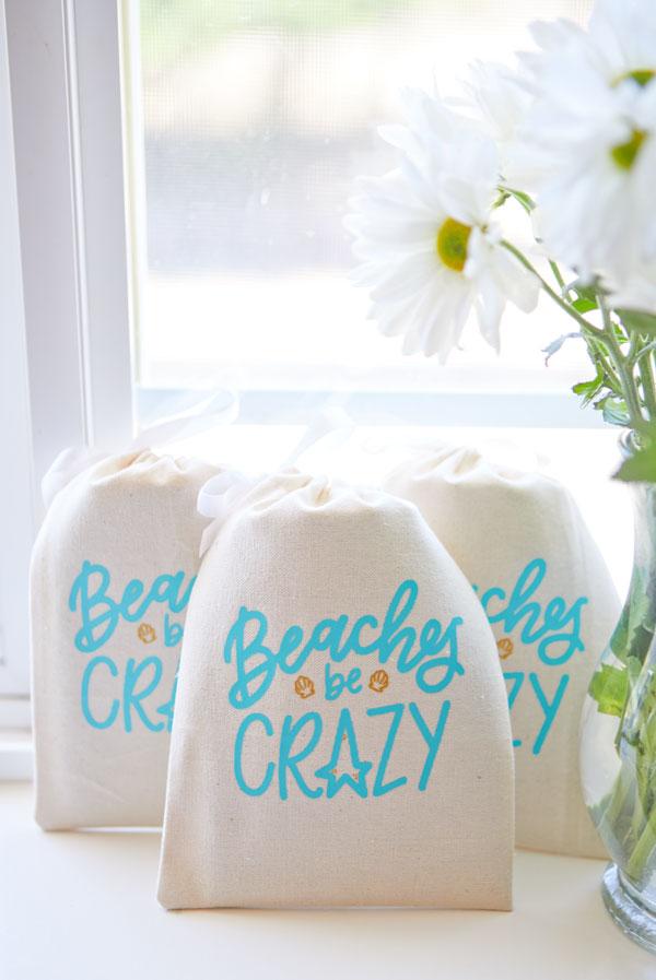 Beaches Be Crazy Hangover Kit Bags featuring glittery gold seashells and minty teal lettering, perfect for beach events and gifts.