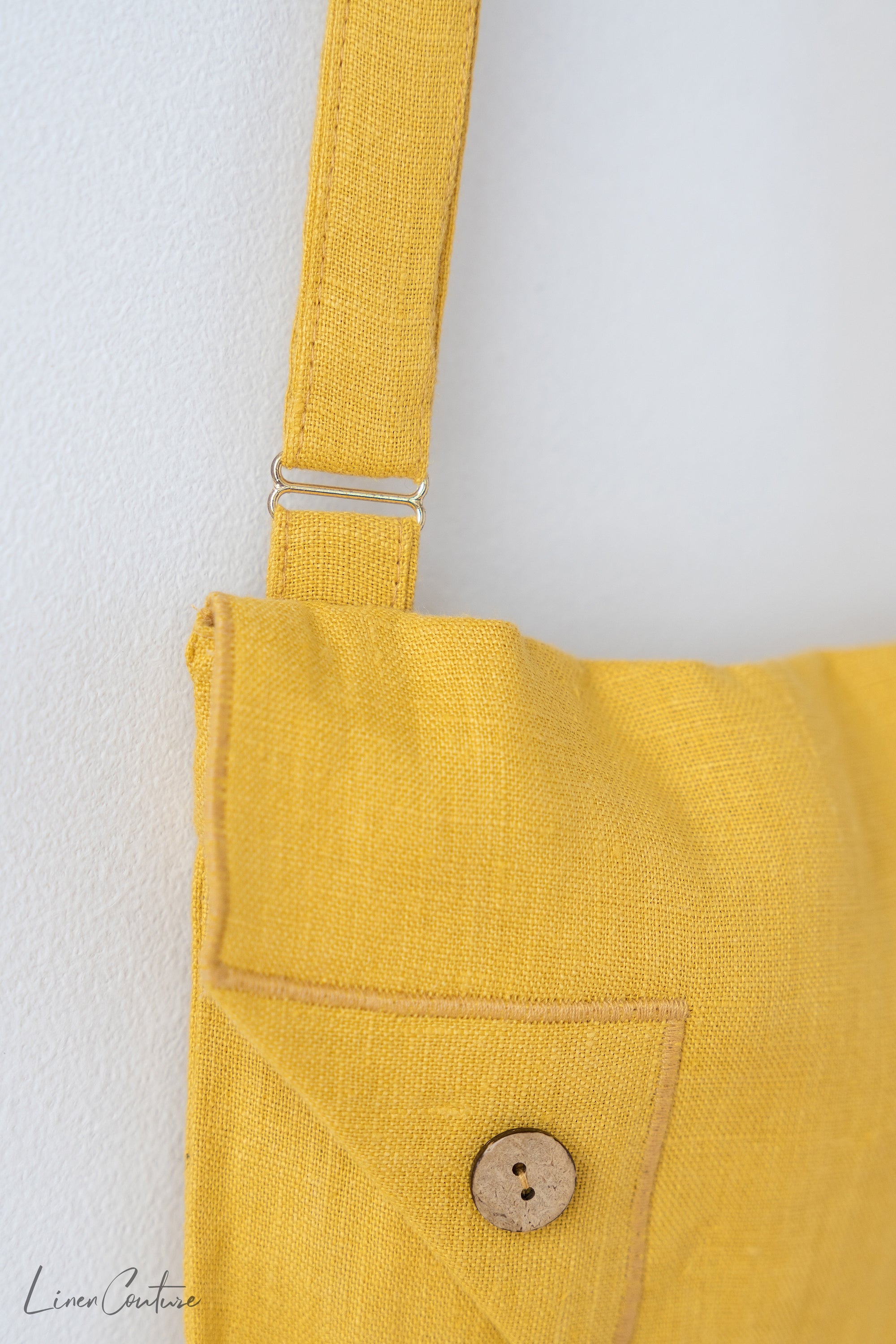 Honey Linen Shoulder Bag featuring coconut buttons and an adjustable strap, showcasing its elegant design and quality linen fabric.