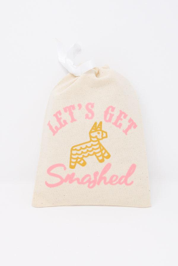 Colorful Let's Get Smashed! Fiesta Hangover Kit Bag featuring a glittery gold piñata design and pink text, perfect for party favors.