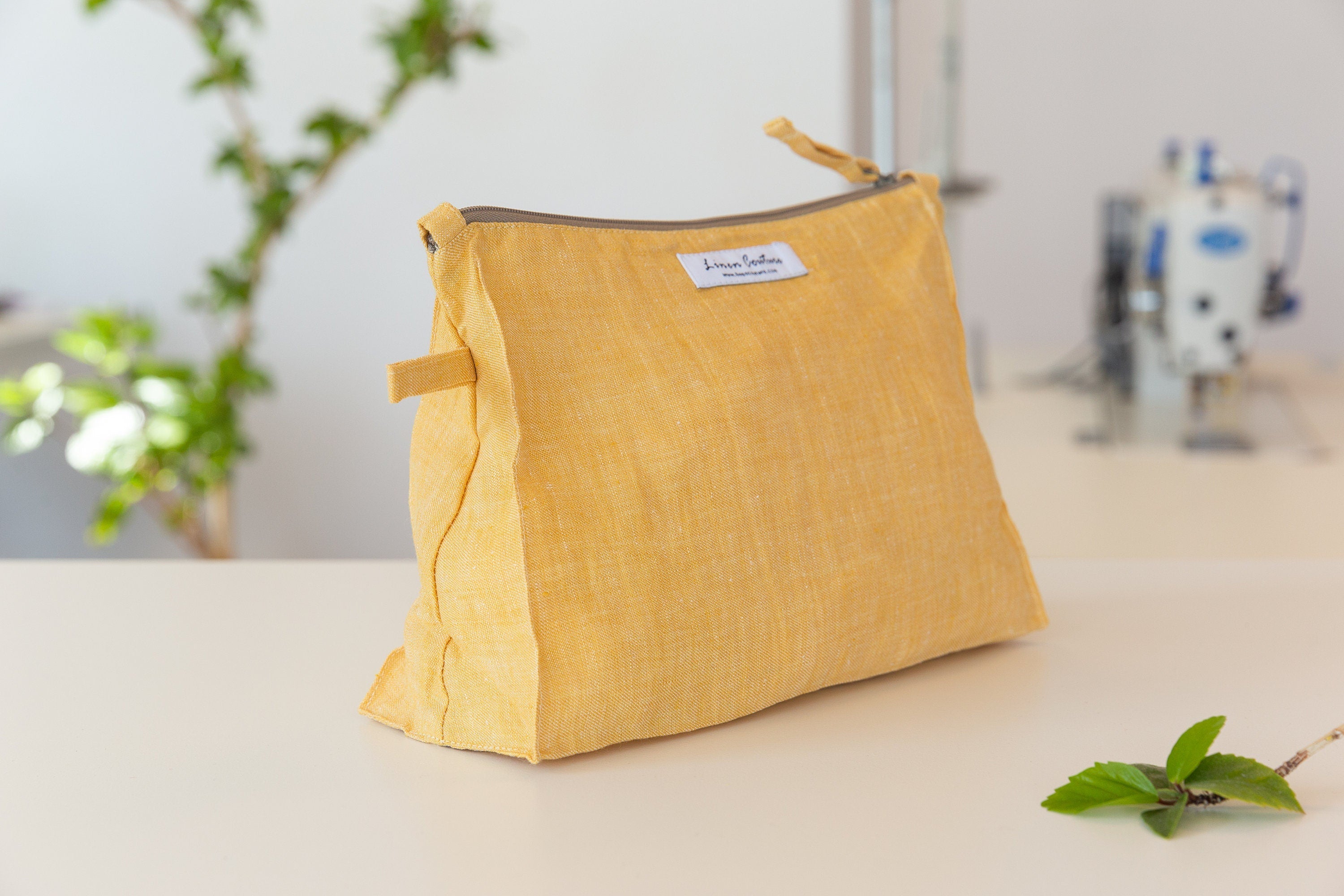 A large reddish brown linen cosmetic bag with zipper closure, showcasing its elegant design and soft texture, perfect for organizing essentials.