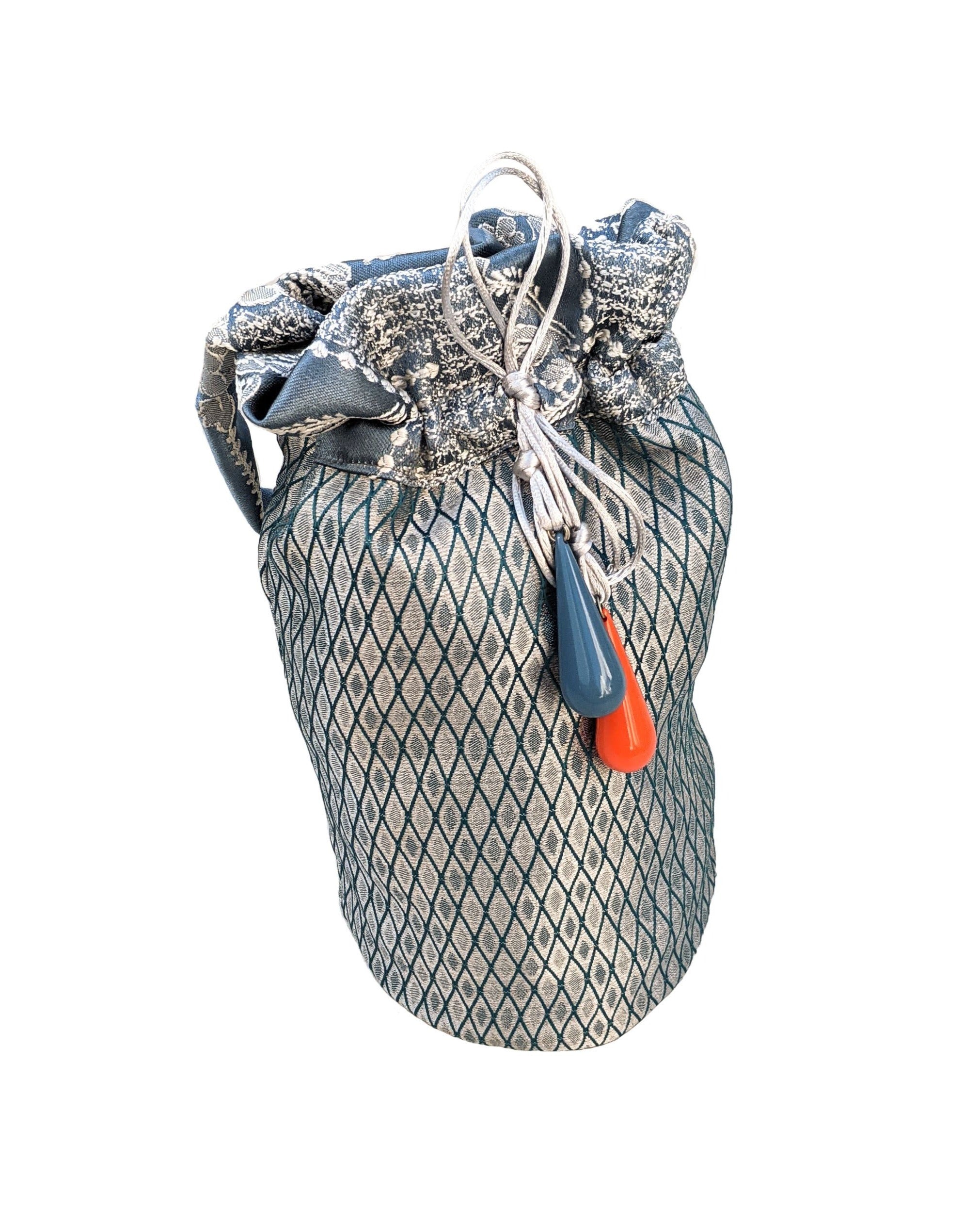 Navy blue pouch shoulder bag with decorative blue and orange glass beads and a jacquard fabric handle.