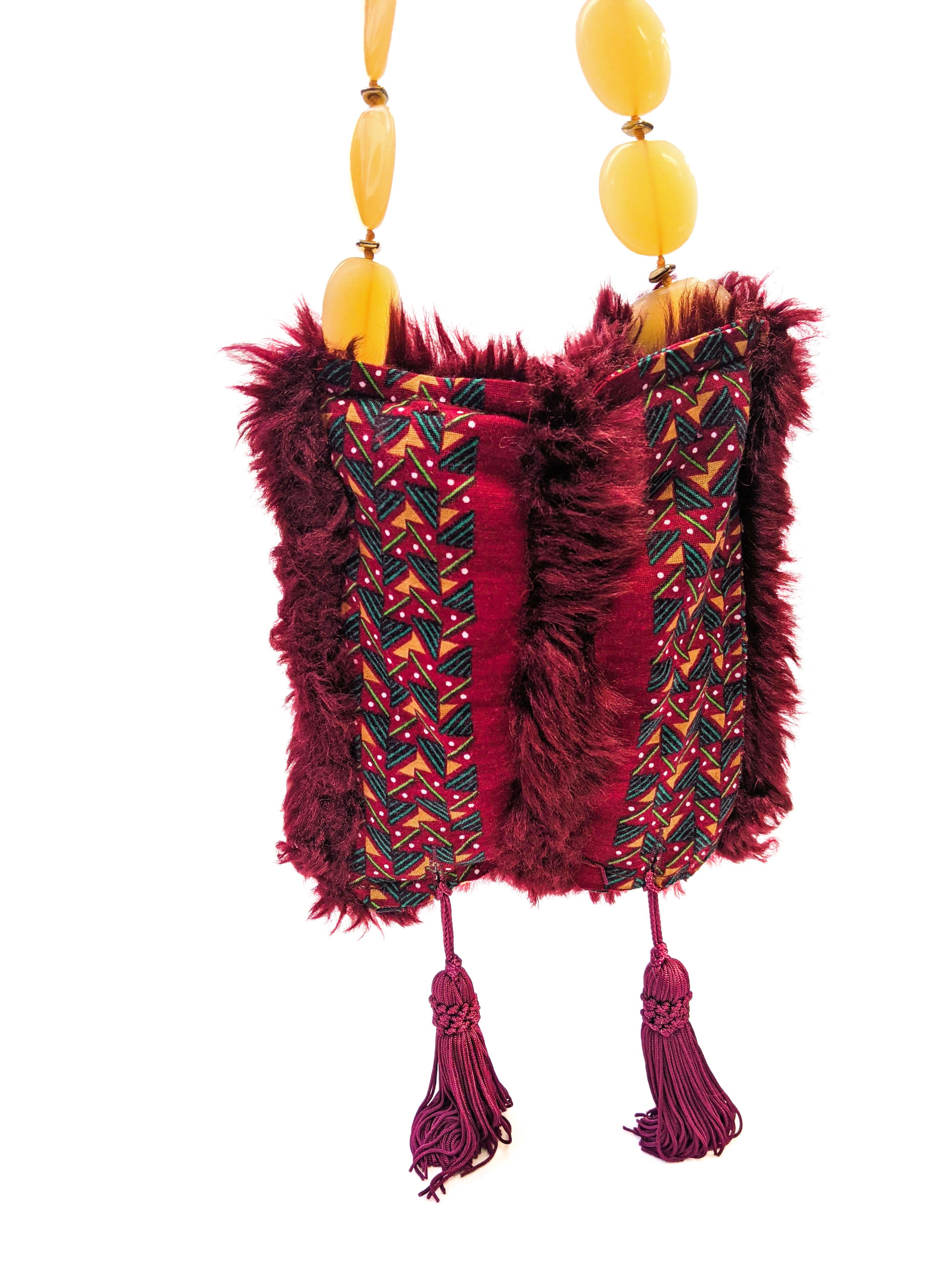 Stylish burgundy fur bag with tassels and yellow bead handle, showcasing unique Brecciated Jasper design.