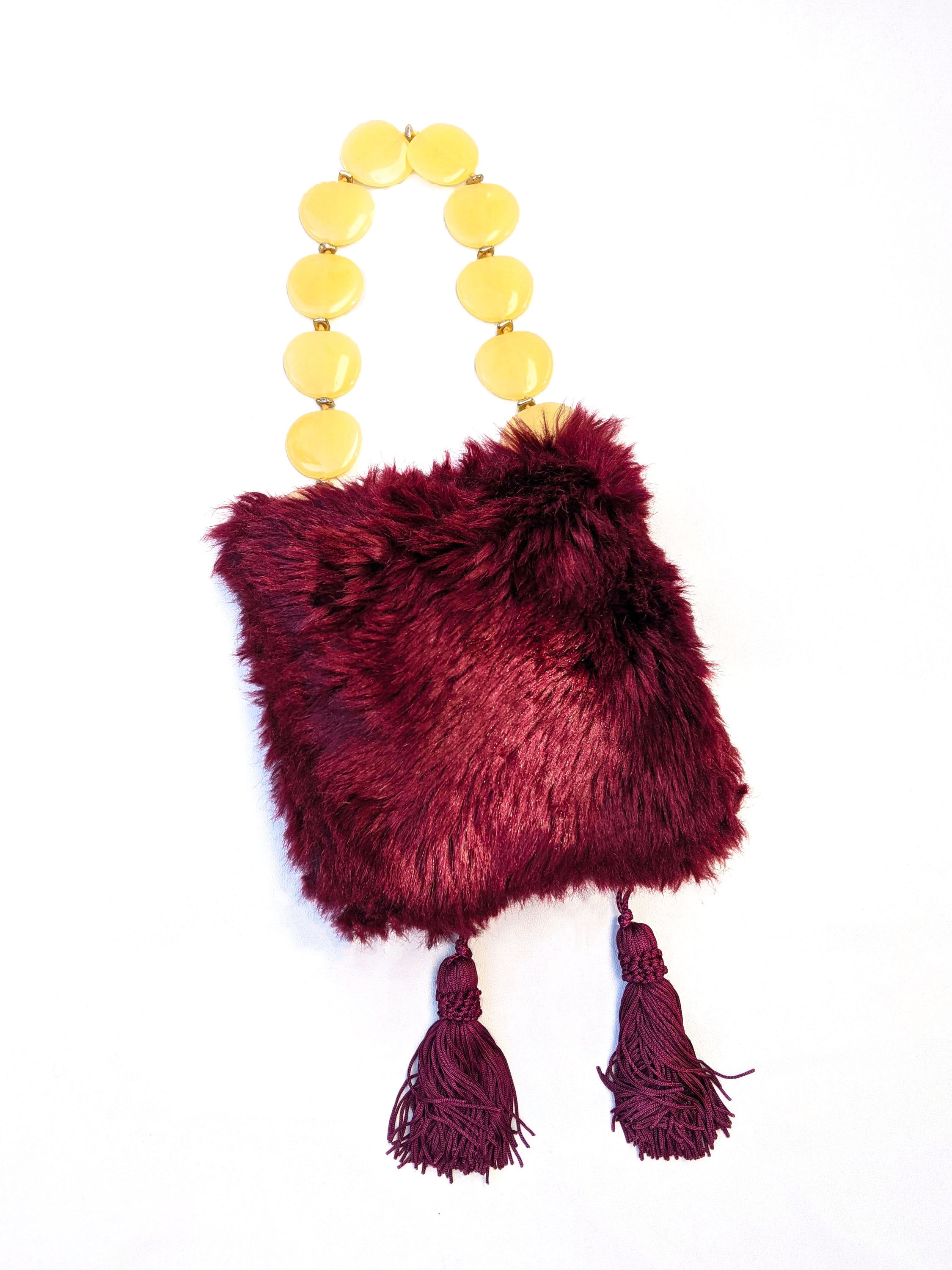 Stylish burgundy fur bag with tassels and yellow bead handle, showcasing unique Brecciated Jasper design.