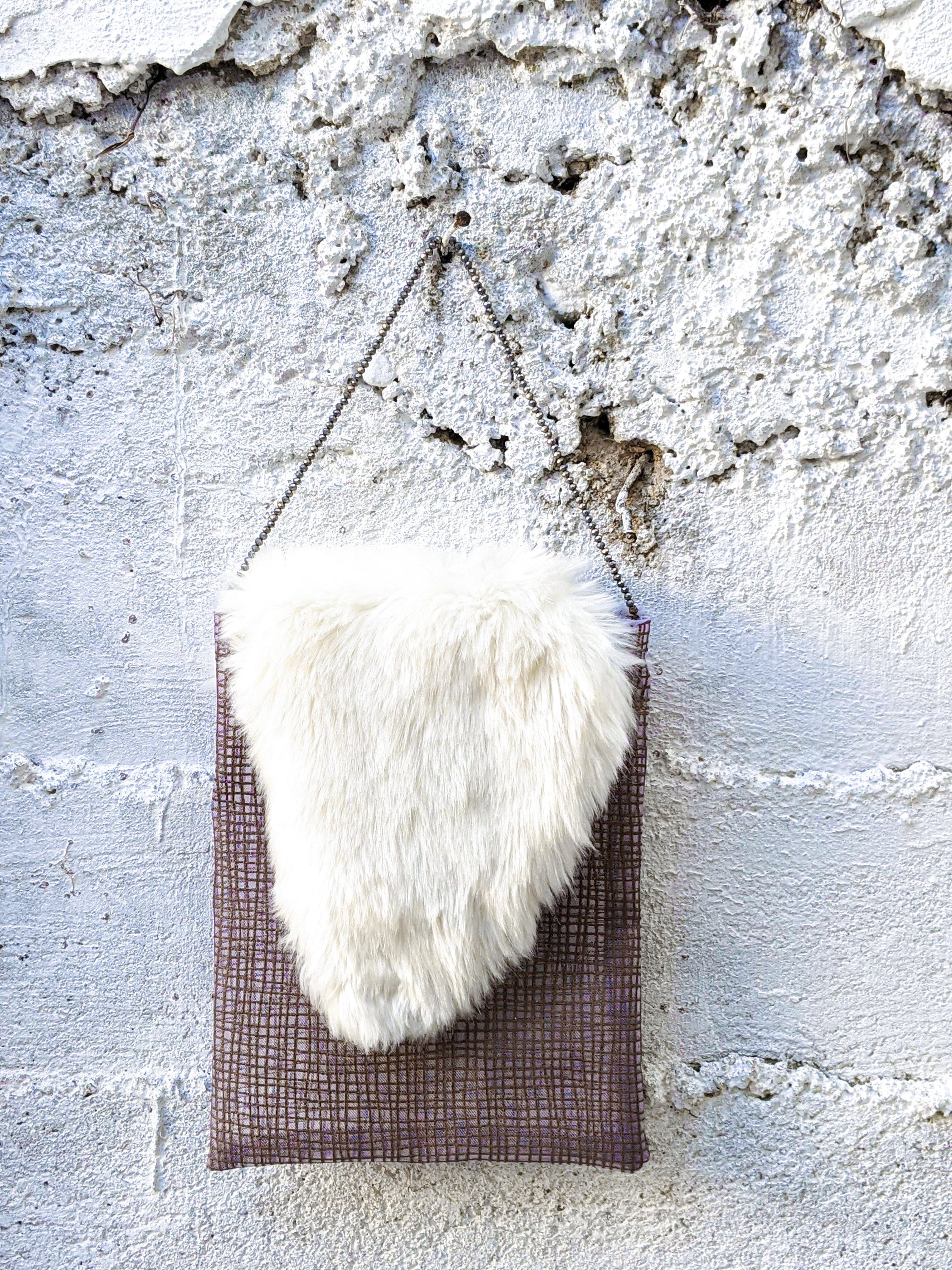 A handcrafted Brown Zebra Jasper featuring a shiny beaded handle and white fur decorations, showcasing unique irregularities.