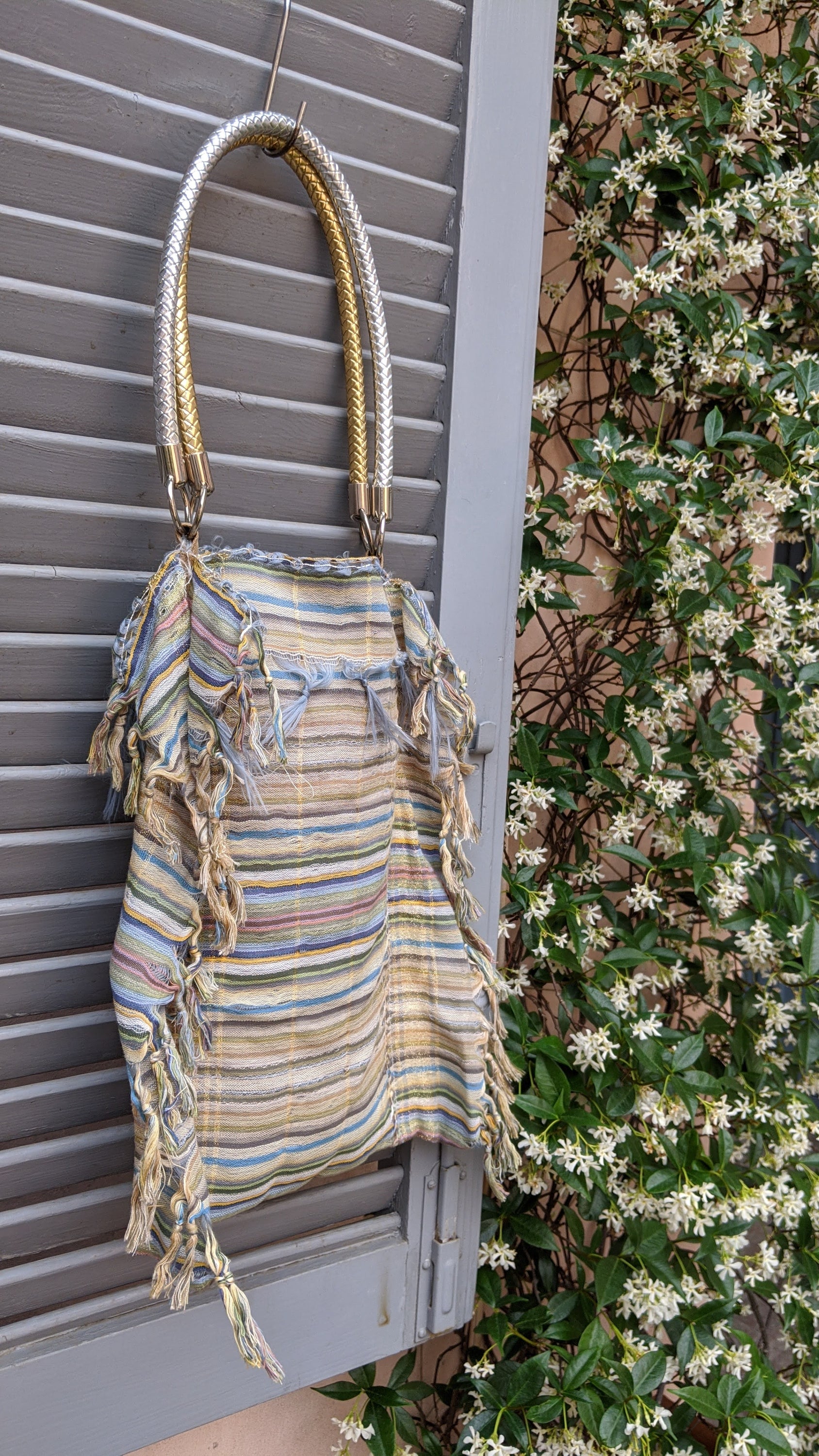 A stylish self-fringed garment named FRINGY, featuring silver and gold handle accessories, showcasing modern upcycled fashion.