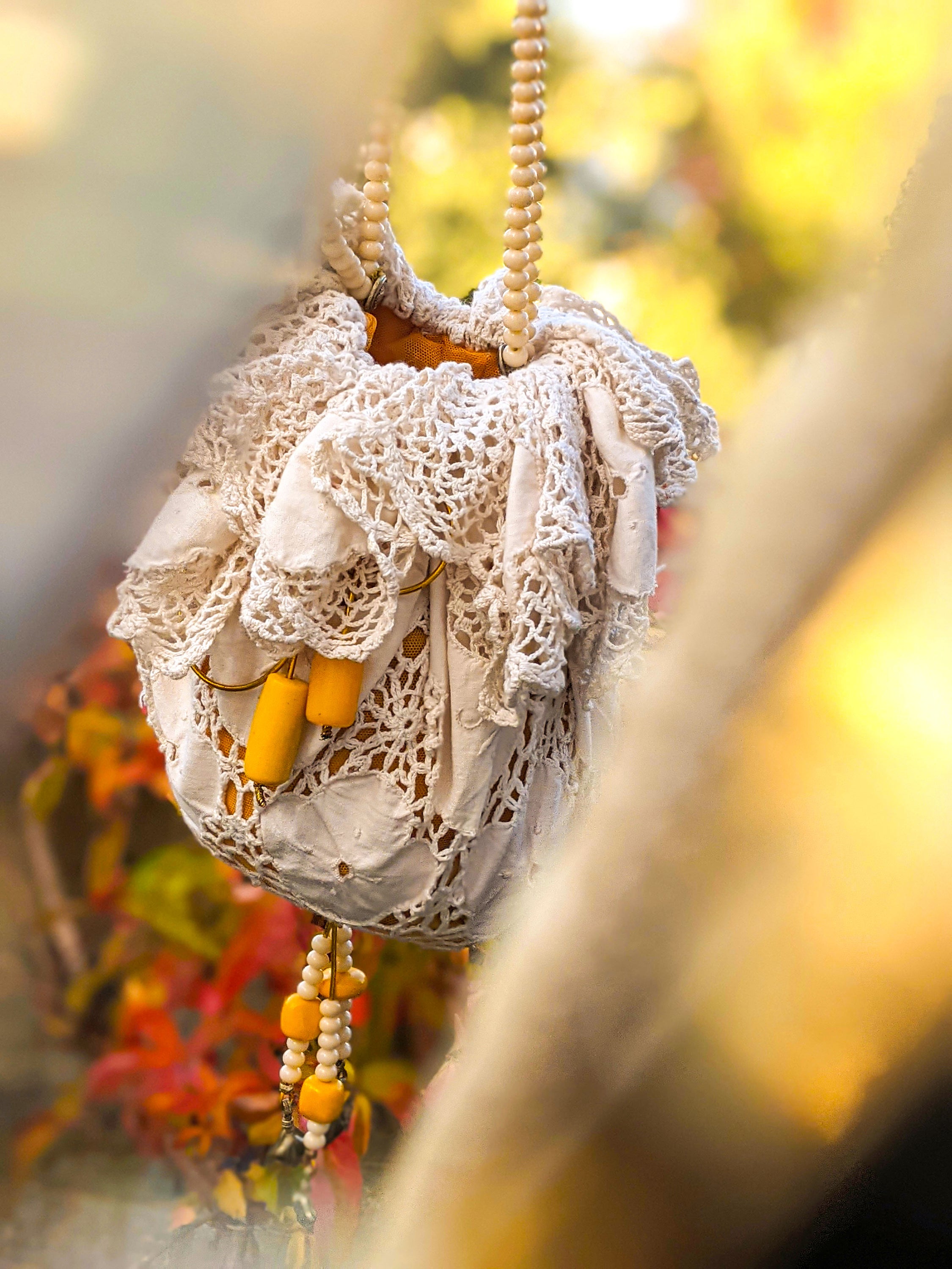 A beautifully crafted Handmade Lace Pouch Bag featuring intricate lacework, tulle lining, and a handle adorned with rosary and resin beads.