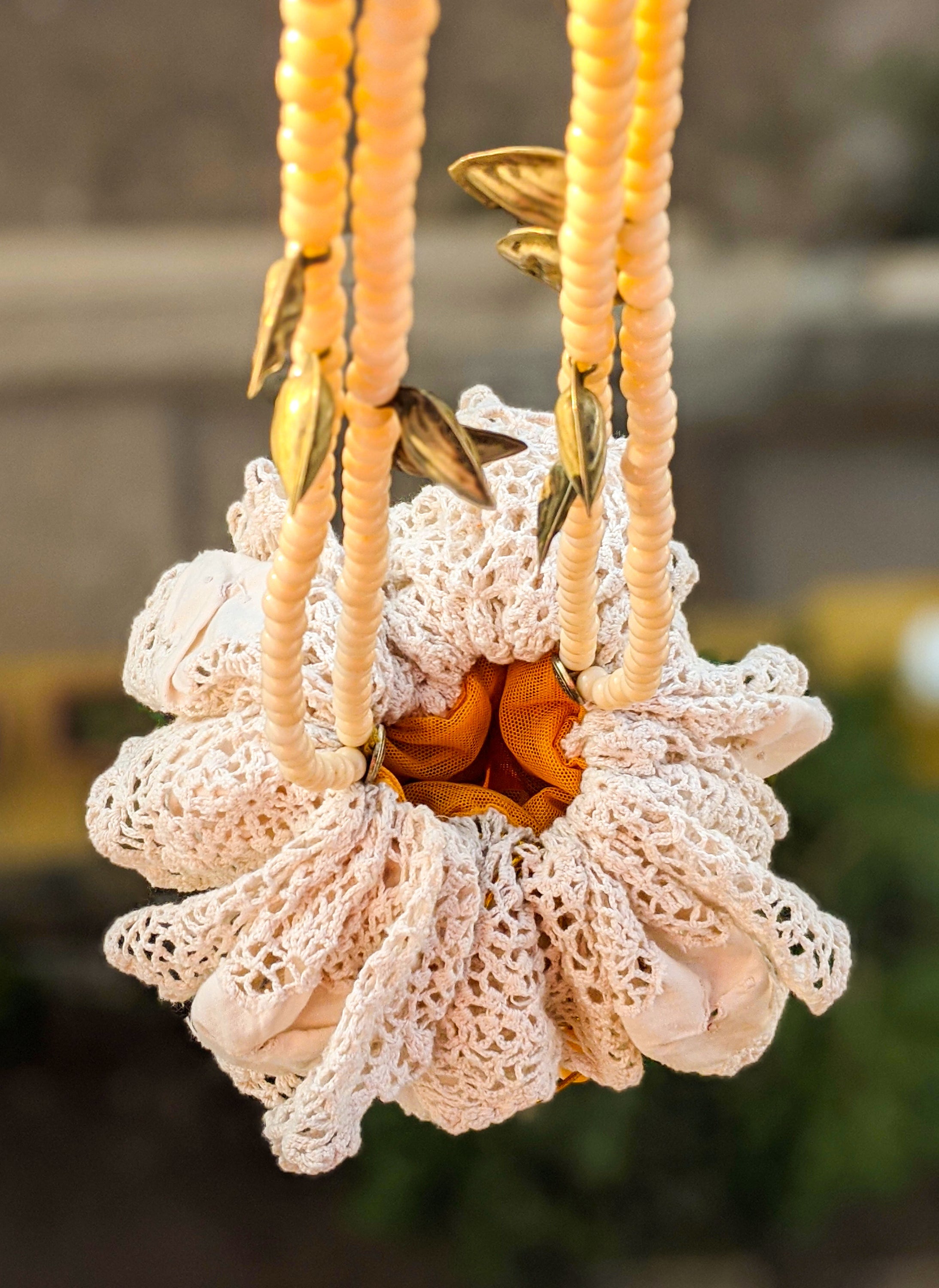 A beautifully crafted Handmade Lace Pouch Bag featuring intricate lacework, tulle lining, and a handle adorned with rosary and resin beads.