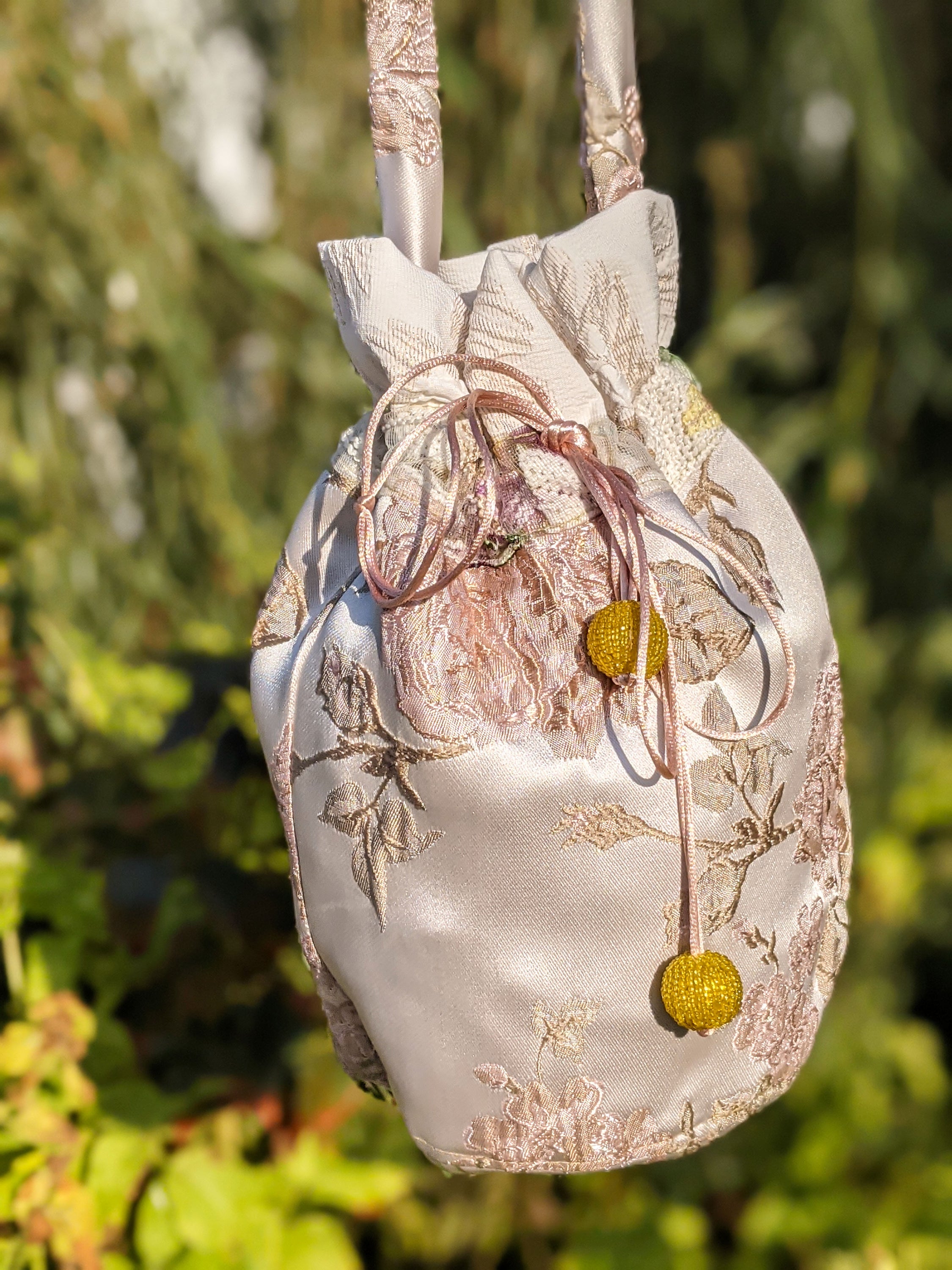 A stylish jacquard pouch shoulder bag featuring a rose pattern and vibrant yellow bead details, perfect for casual outings.