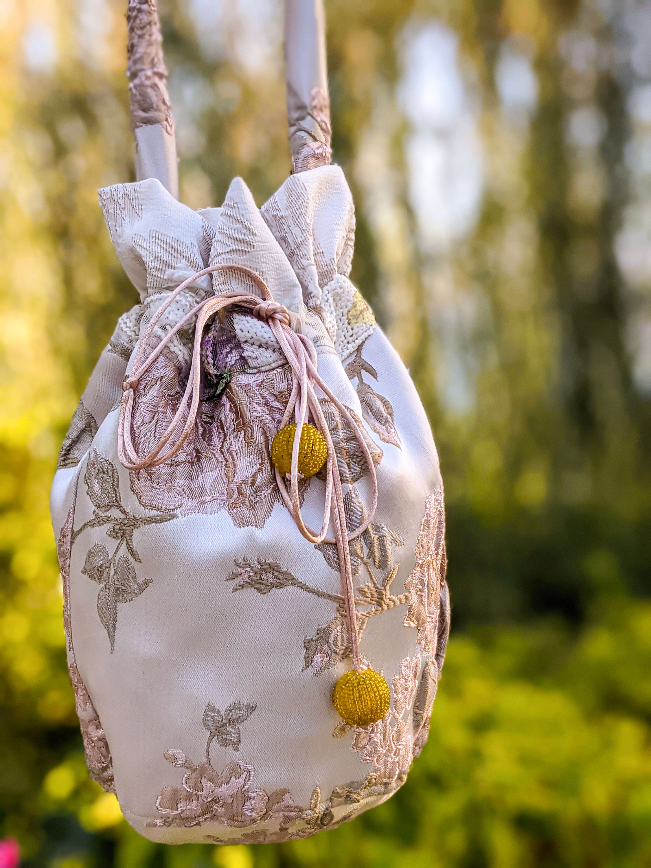 A stylish jacquard pouch shoulder bag featuring a rose pattern and vibrant yellow bead details, perfect for casual outings.