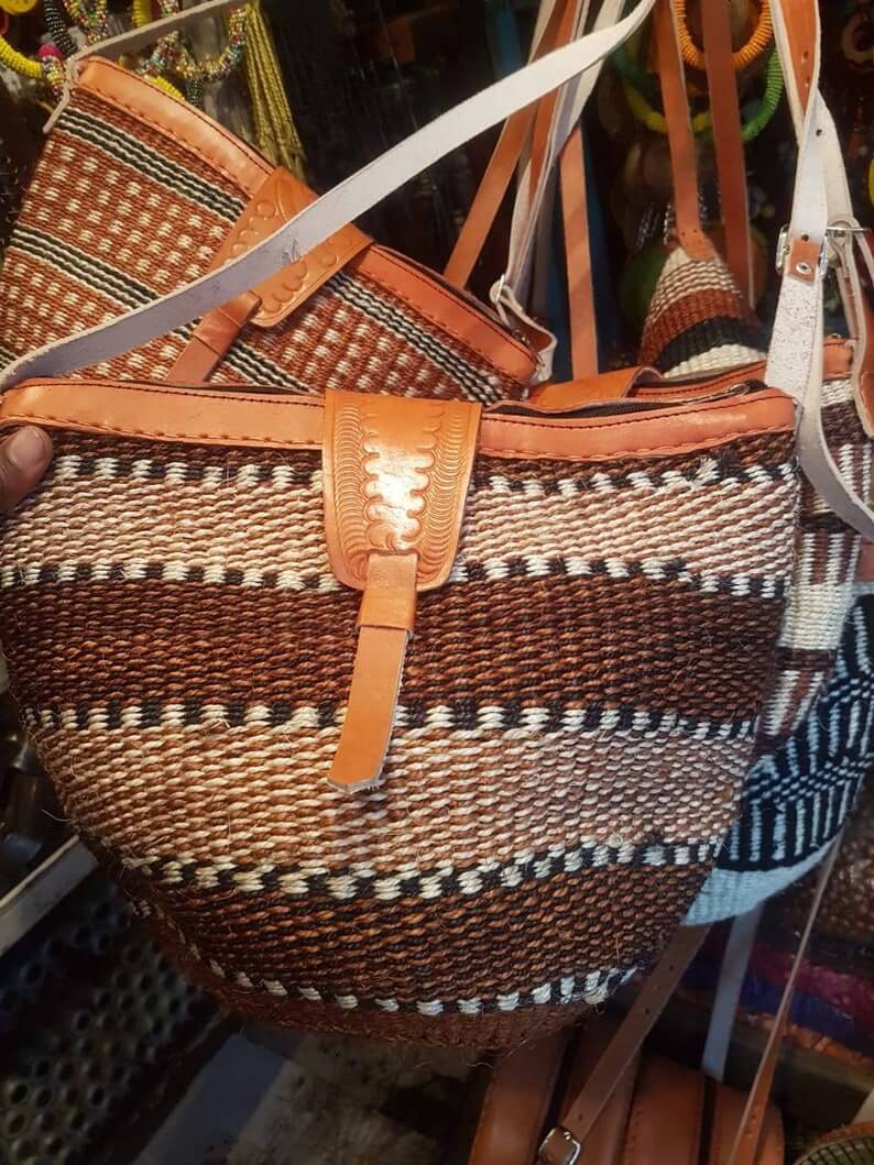 Kikuyu traditional handwoven African crossbody bag made from sisal and leather, featuring a zipper closure and cotton lining, showcasing unique patterns.