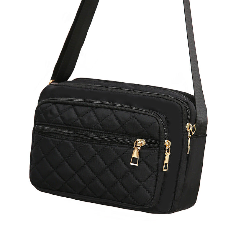 Ladies' Nylon Quilted Bag featuring a stylish quilted design, multiple zipper pockets, and an adjustable strap for versatile use.