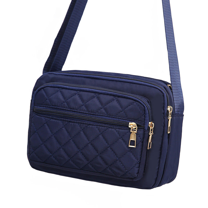 Ladies' Nylon Quilted Bag featuring a stylish quilted design, multiple zipper pockets, and an adjustable strap for versatile use.