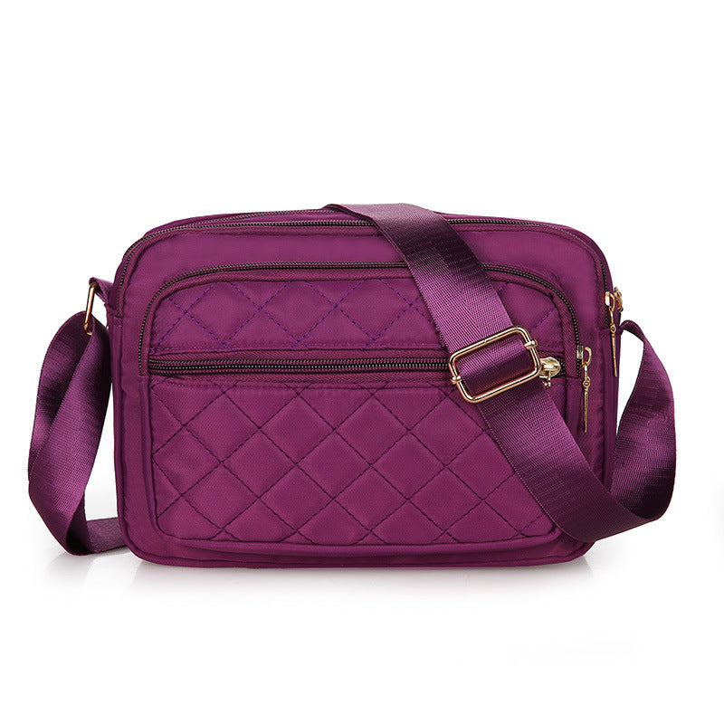 Ladies' Nylon Quilted Bag featuring a stylish quilted design, multiple zipper pockets, and an adjustable strap for versatile use.