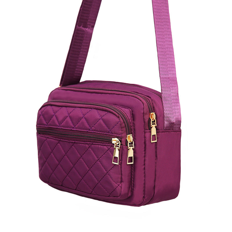 Ladies' Nylon Quilted Bag featuring a stylish quilted design, multiple zipper pockets, and an adjustable strap for versatile use.