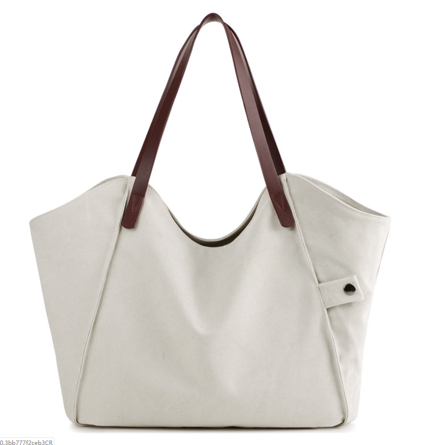 Large-capacity canvas shoulder bag for women, featuring a stylish design with soft handles and multiple pockets for organization.