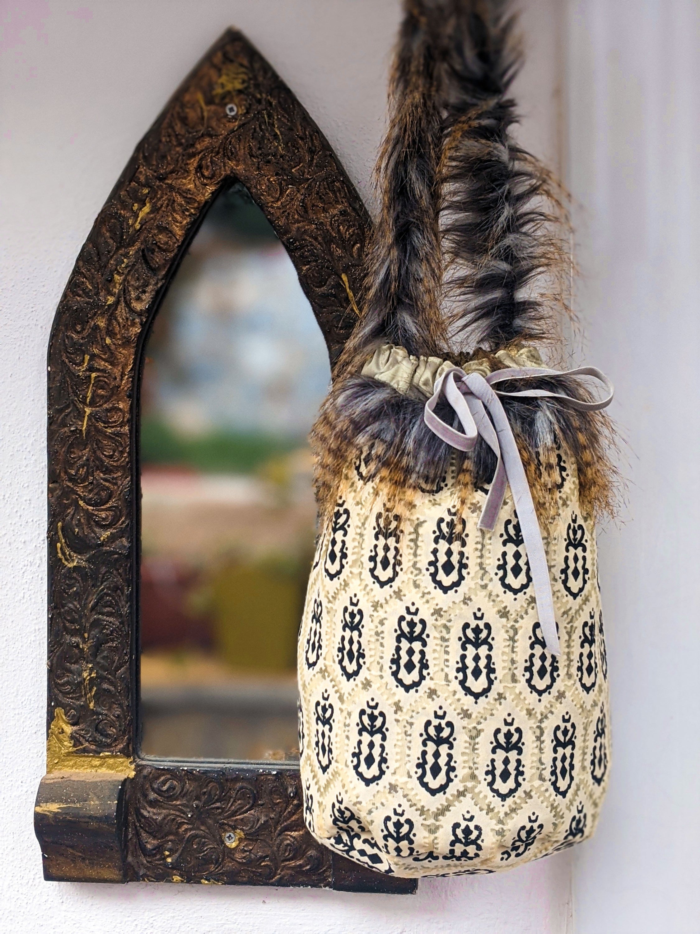 Leopard Skin Jasper pouch bag with faux fur handle and grey velvet elastic rope, showcasing its unique design and texture.