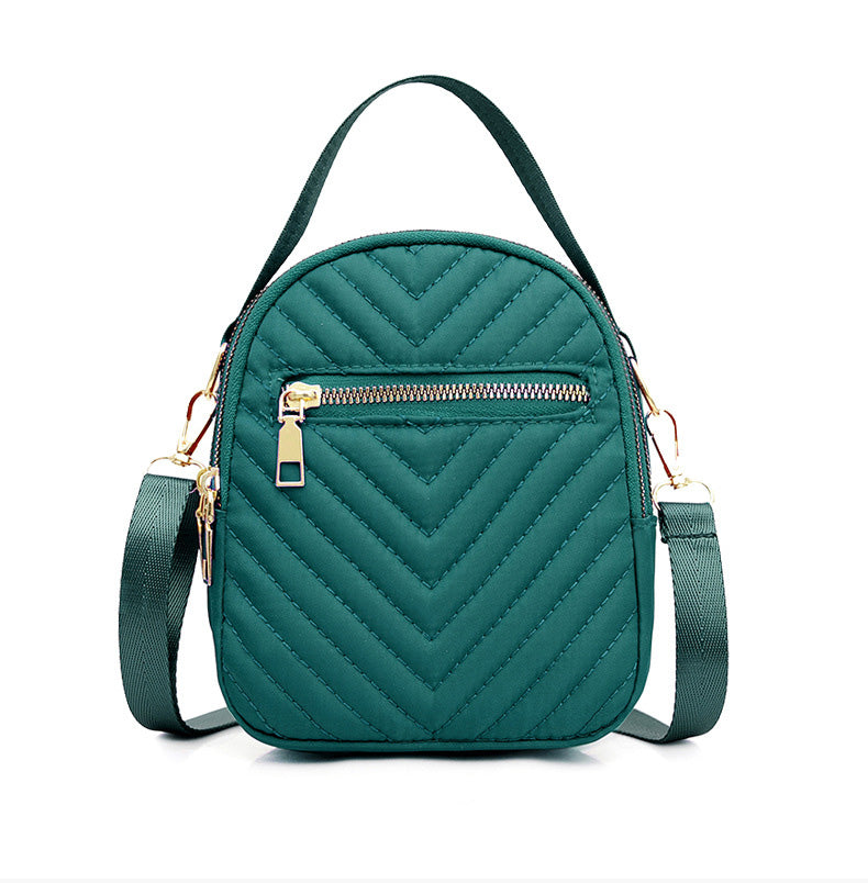 A stylish nylon quilted bag featuring multiple zipper pockets, adjustable strap, and gold-tone hardware.