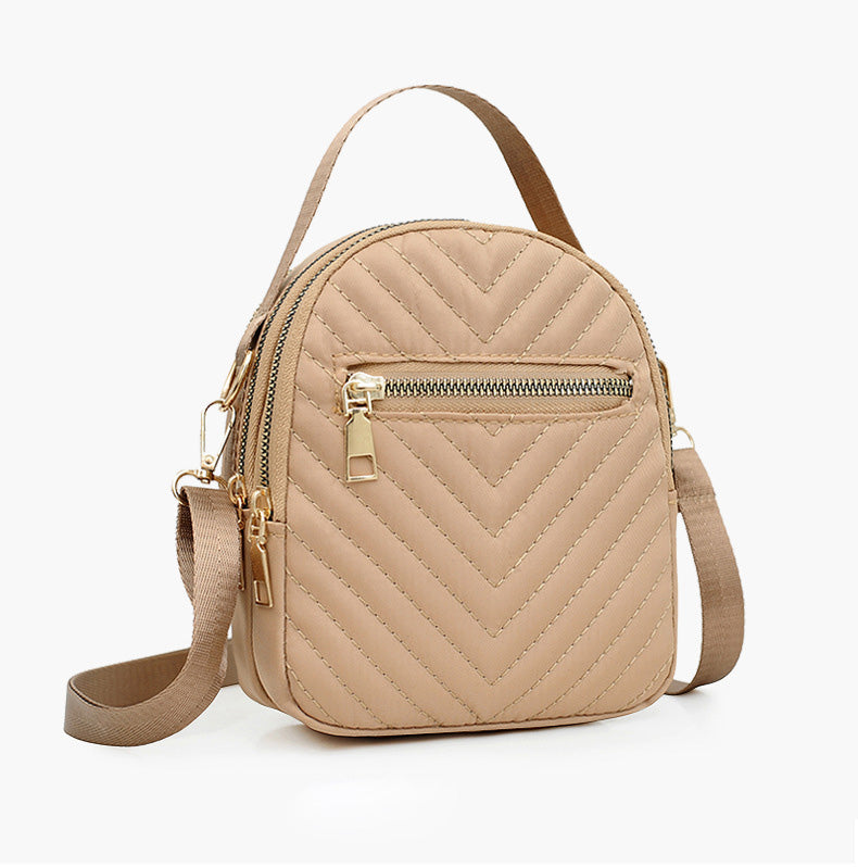 A stylish nylon quilted bag featuring multiple zipper pockets, adjustable strap, and gold-tone hardware.