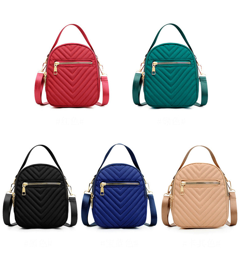 A stylish nylon quilted bag featuring multiple zipper pockets, adjustable strap, and gold-tone hardware.