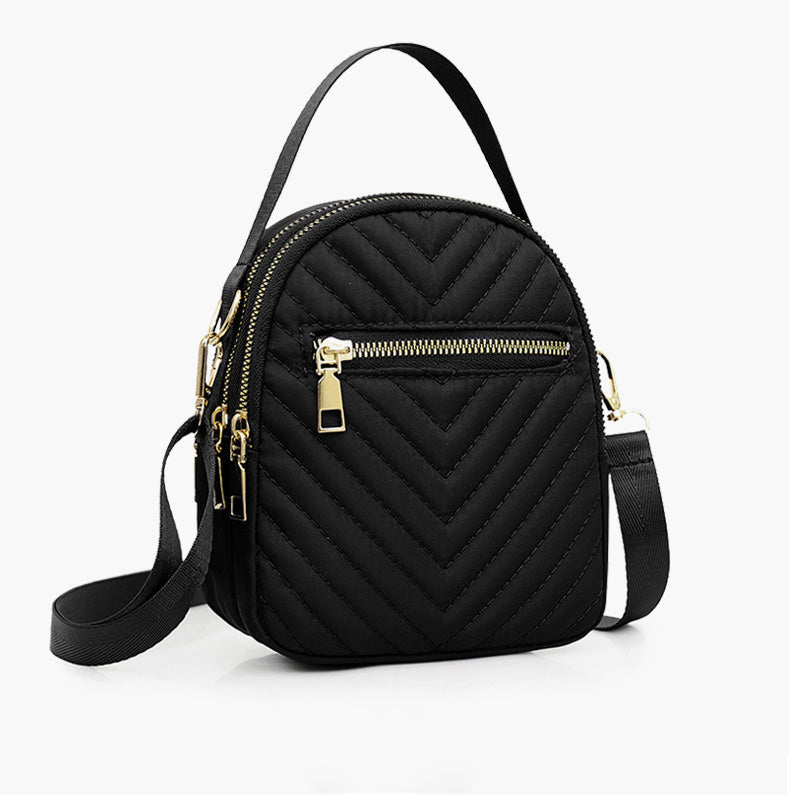 A stylish nylon quilted bag featuring multiple zipper pockets, adjustable strap, and gold-tone hardware.