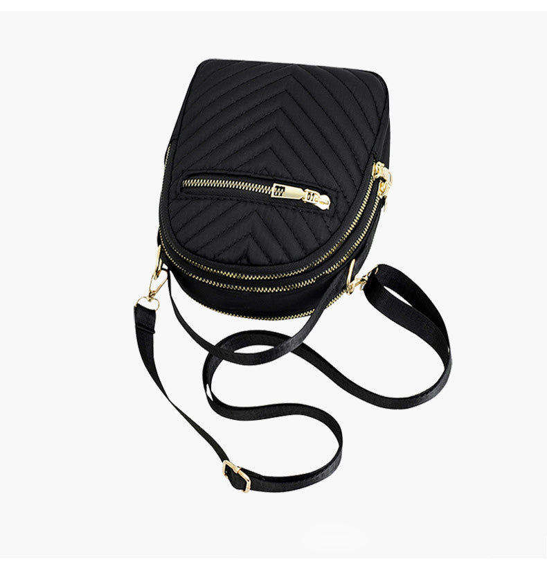 A stylish nylon quilted bag featuring multiple zipper pockets, adjustable strap, and gold-tone hardware.