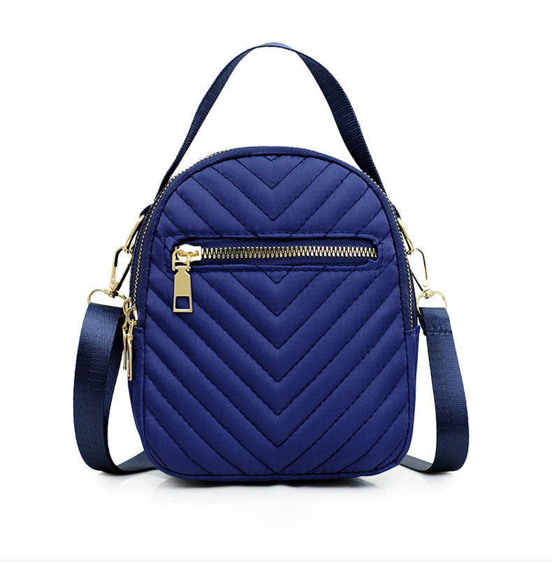 A stylish nylon quilted bag featuring multiple zipper pockets, adjustable strap, and gold-tone hardware.