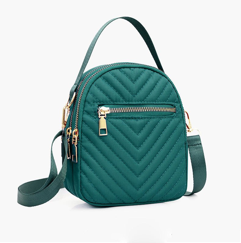 A stylish nylon quilted bag featuring multiple zipper pockets, adjustable strap, and gold-tone hardware.