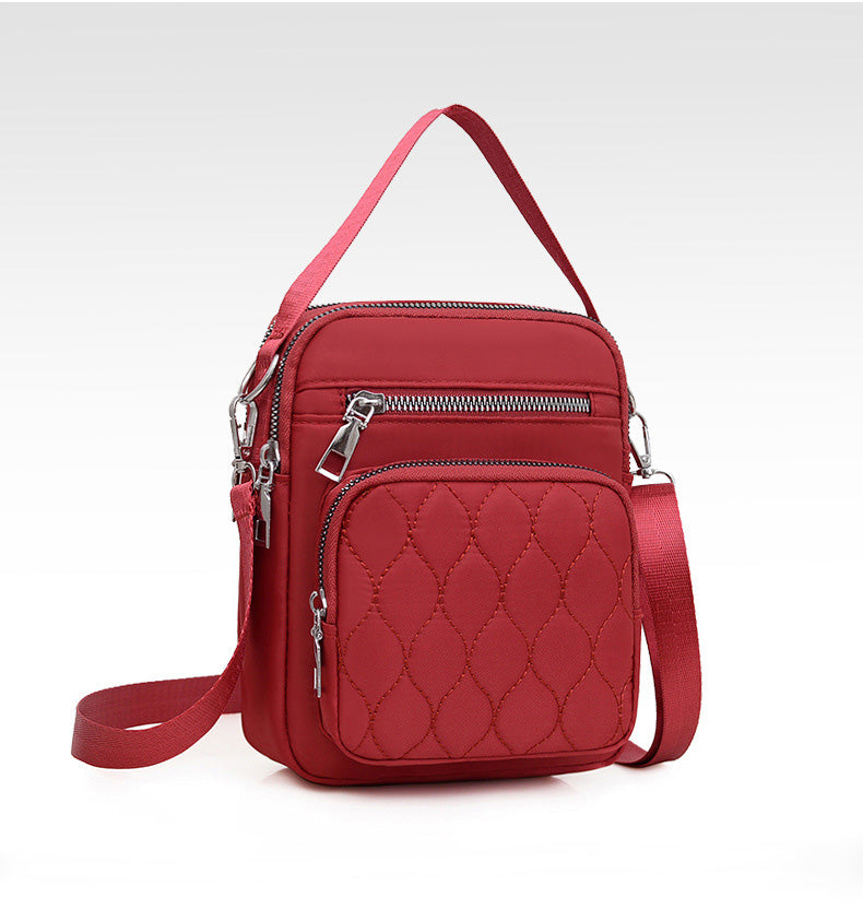 A stylish NYLON QUILTED BAG in black, featuring multiple zipper pockets and an adjustable strap, perfect for daily use.