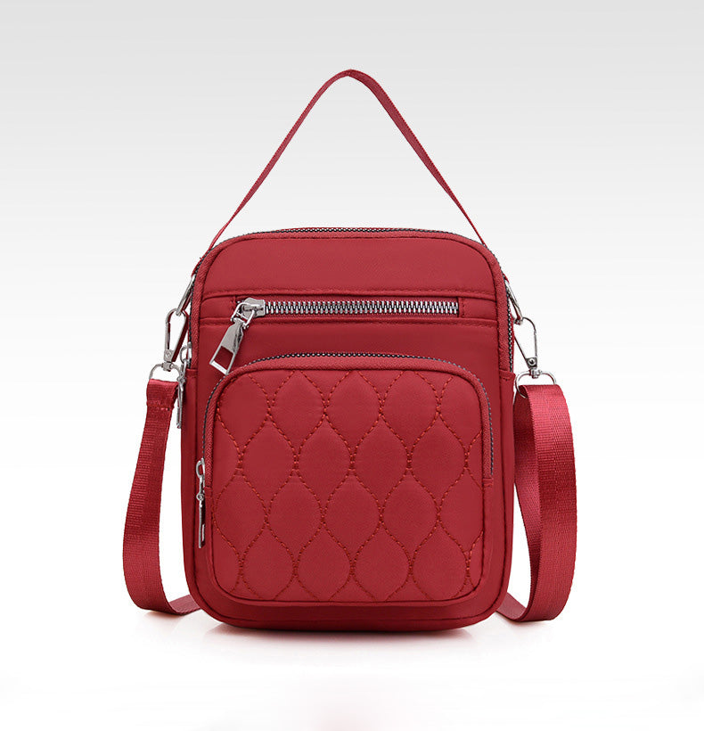 A stylish NYLON QUILTED BAG in black, featuring multiple zipper pockets and an adjustable strap, perfect for daily use.