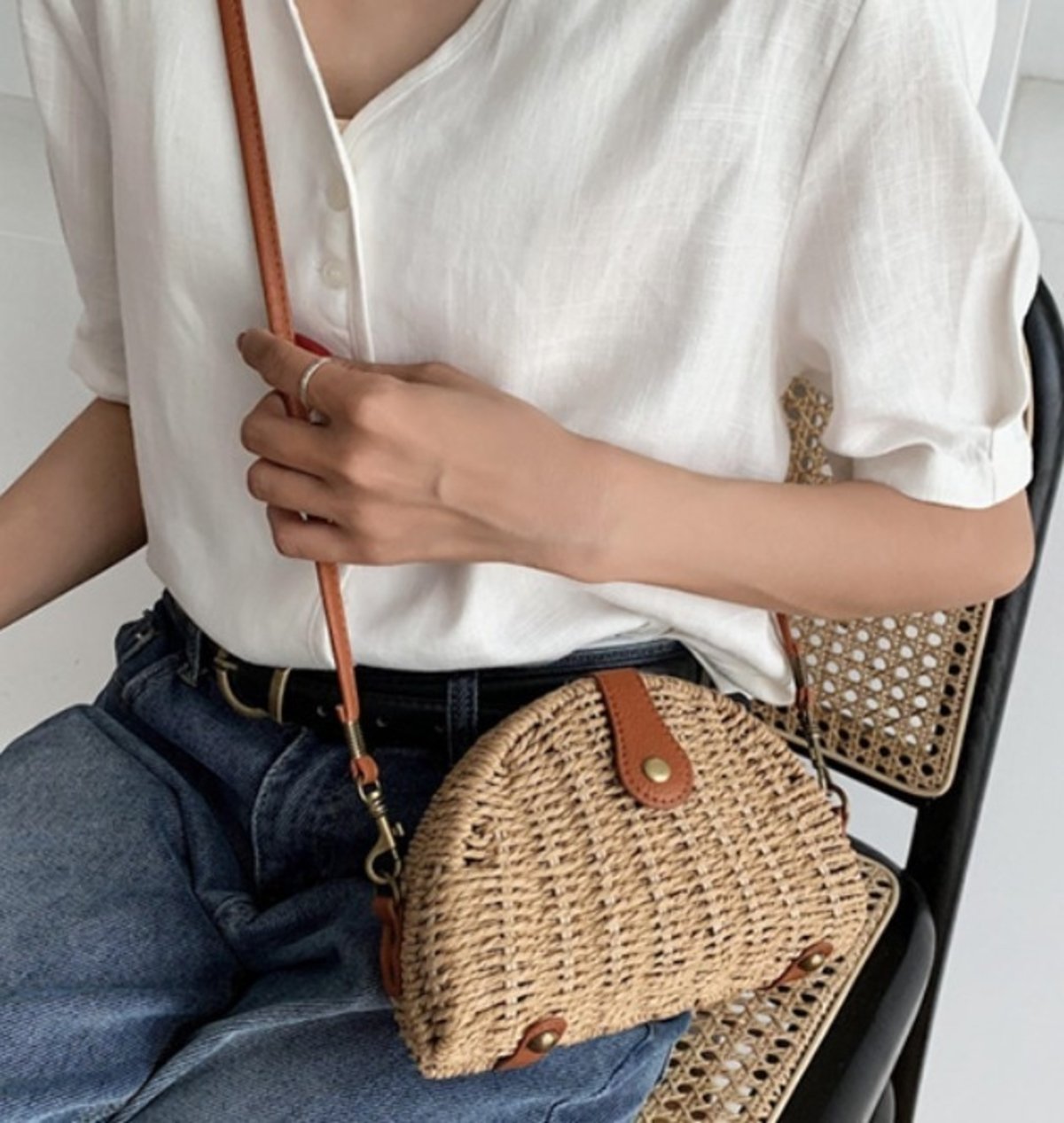 Oval Straw Small Crossbody Bag in khaki color, made from wicker straw, showcasing its stylish design and adjustable strap.