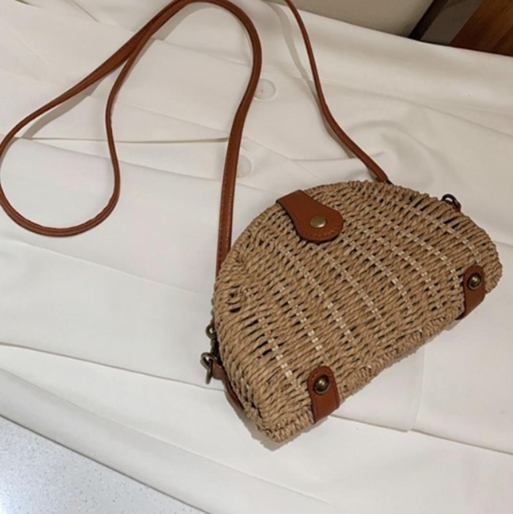 Oval Straw Small Crossbody Bag in khaki color, made from wicker straw, showcasing its stylish design and adjustable strap.