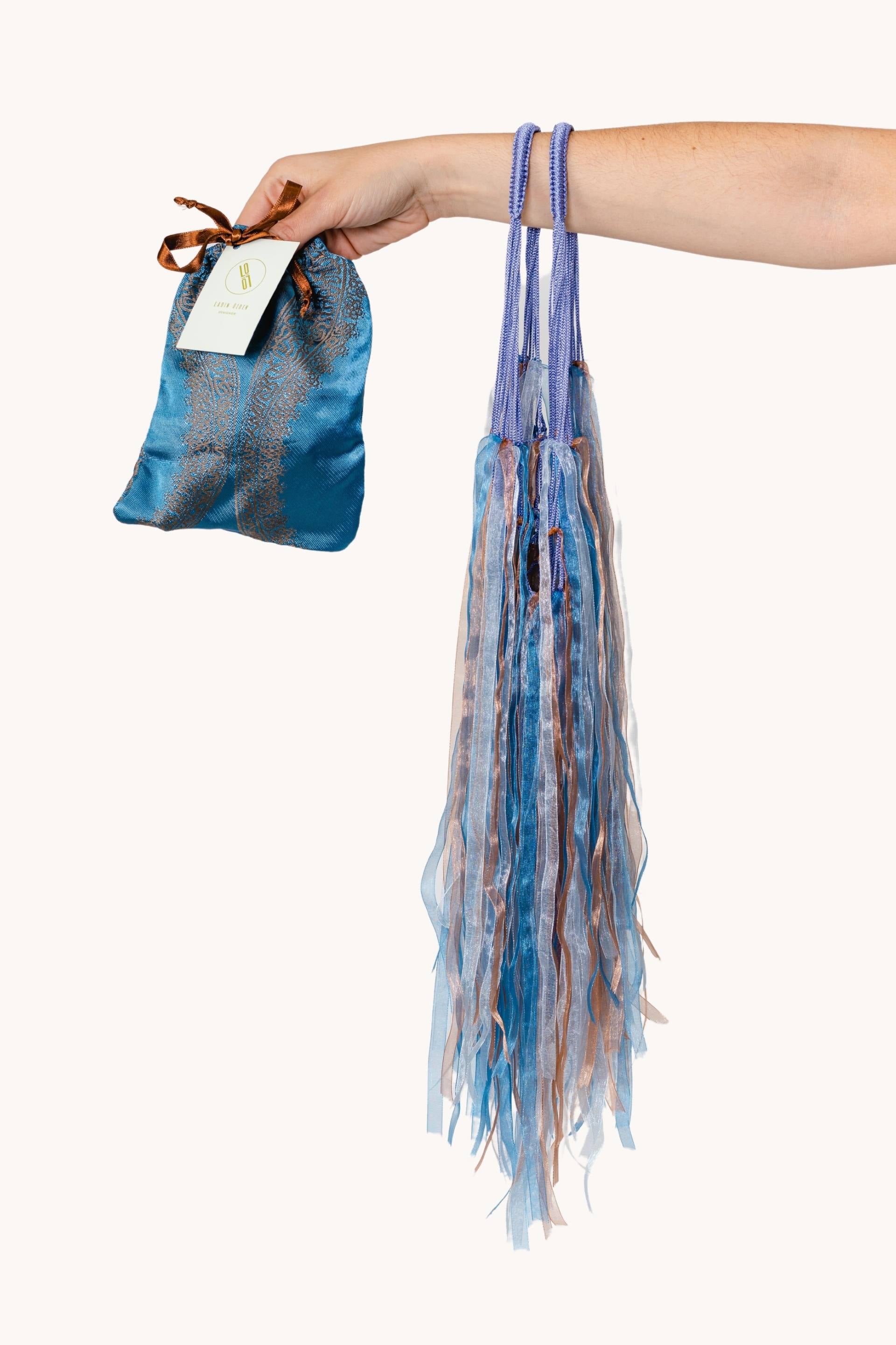 A stylish blue-violet fishnet bag adorned with blue-brown ribbons, showcasing its elegant design and versatility.