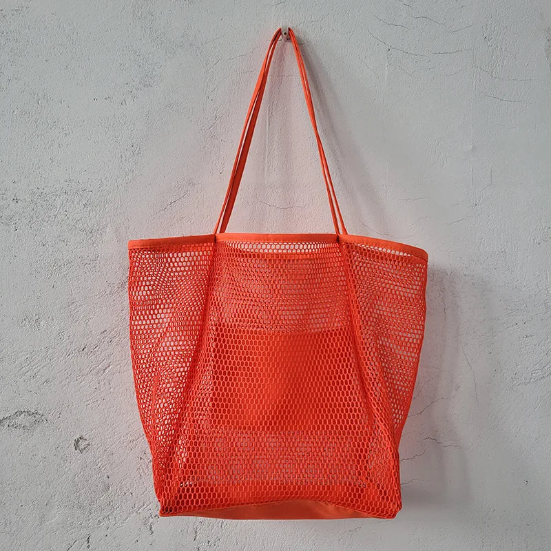 A large capacity hollow mesh tote bag in solid color, perfect for travel and beach outings, showcasing its lightweight and foldable design.