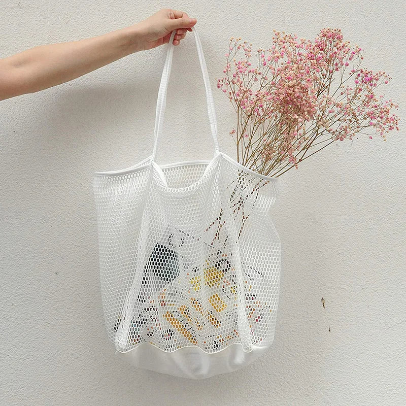 A large capacity hollow mesh tote bag in solid color, perfect for travel and beach outings, showcasing its lightweight and foldable design.