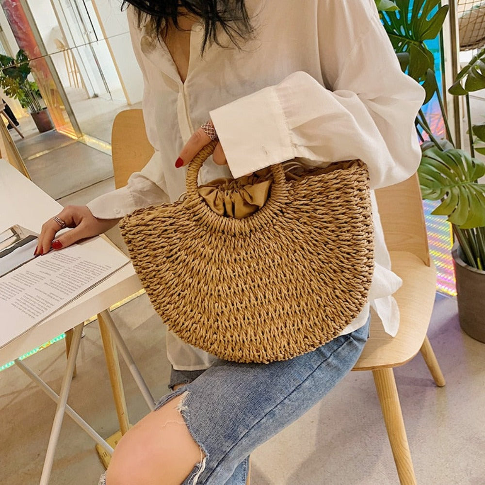 A stylish Summer Top Handle Semi Circle Straw Bag, showcasing its trendy semi-circle shape and lightweight straw material, perfect for summer outings.