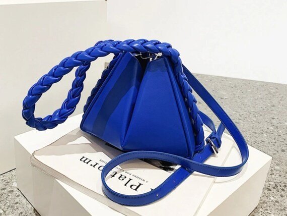 Triangle Me Crossbody bag featuring a braided handle in vibrant colors, perfect for versatile styling.