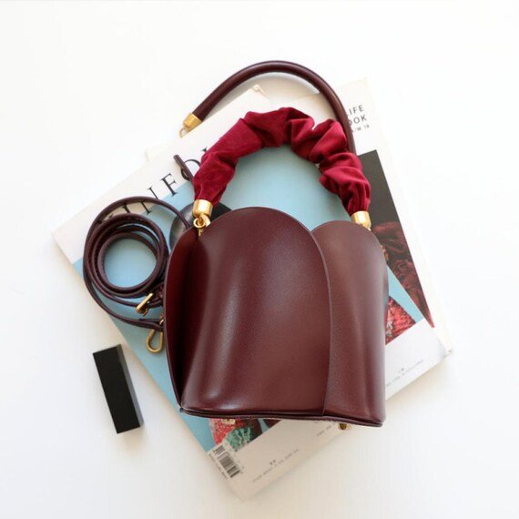 Tulip Leather Bucket bag featuring a unique four-bladed design and frilled handle, made from genuine leather.